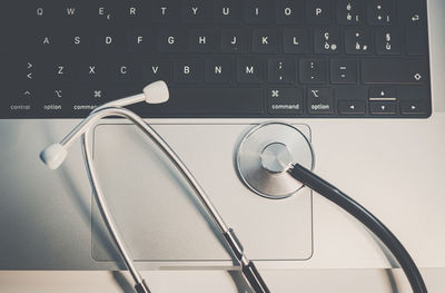 High angle view of stethoscope on computer keyboard