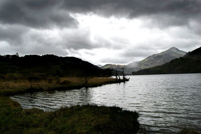 Scenic view of river against cloudy sky
