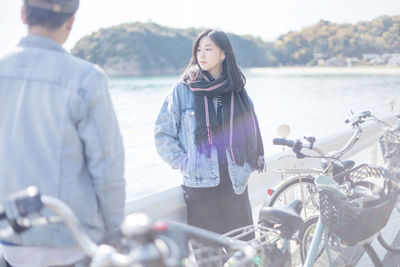 Young woman standing by sea