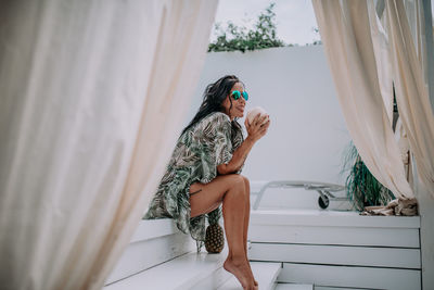 Woman wearing sunglasses sitting outdoors