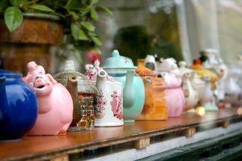 Close-up of teapots on rack at store