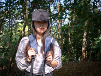 Portrait of young woman standing in forest