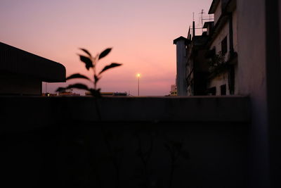 Silhouette buildings against sky at sunset