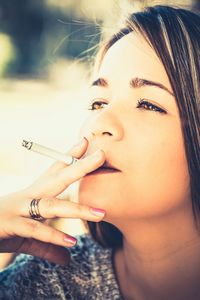 Cropped image of woman holding cigarette