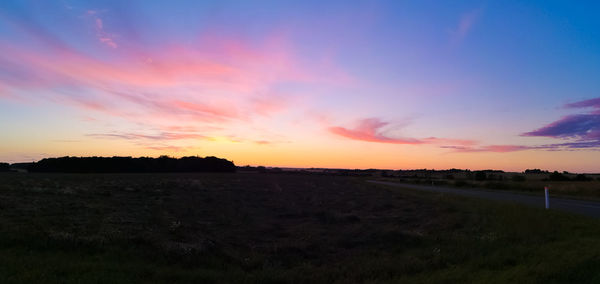 Scenic view of field against sky during sunset
