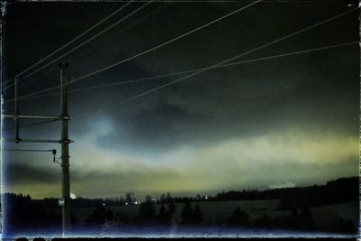 Power lines against cloudy sky