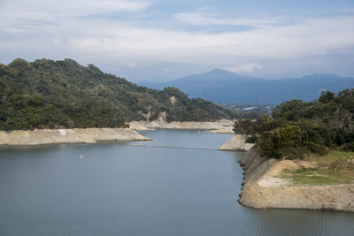 Scenic view of sea and mountains against sky