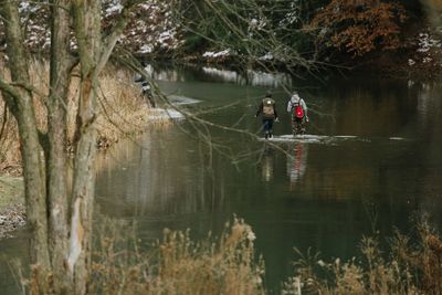 Man in river with trees in background