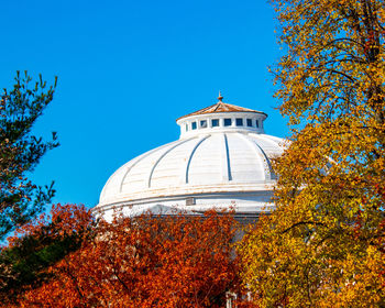 Low angle view of trees and building against sky