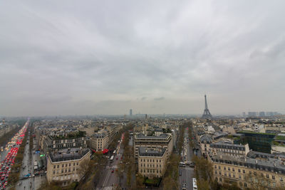 High angle view of city buildings against cloudy sky