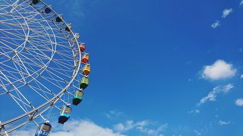 Low angle view of ferris wheel against blue sky