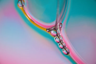 Close-up of multi colored water drop on blue background