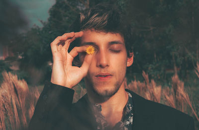 Portrait of young man holding plant