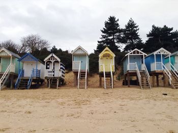 Houses by beach against sky