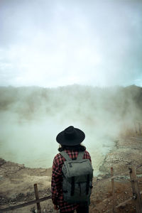 Rear view of man looking at camera