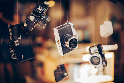 Close-up of retro cameras hanging from string