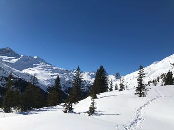 Scenic view of snowcapped mountains against clear blue sky