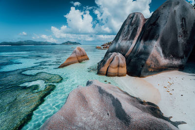 Rocks at beach against sky