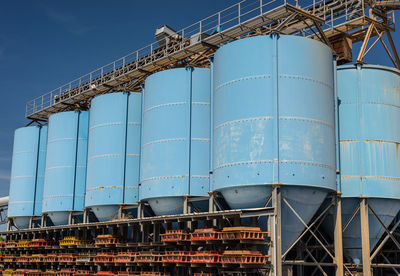 Big blue metallic industrial silos for the production of cement at an industrial cement plant