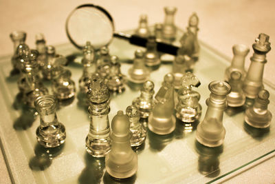 High angle view of glass chess pieces on board