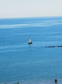 Sailboat in sea against clear sky