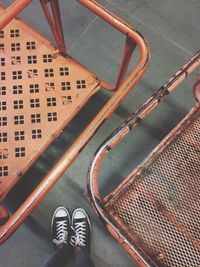 Low section of person standing by metallic carts on floor