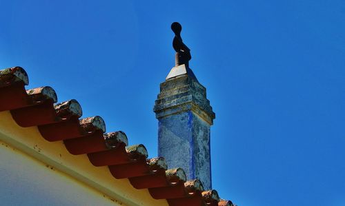 Low angle view of statue against clear blue sky