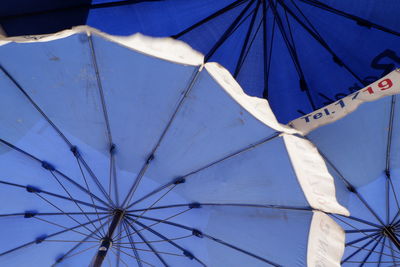 Low angle view of umbrella against blue sky