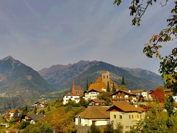 Townscape by mountains against sky