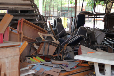 The pile of garbage which include some wooden tables and wooden chairs