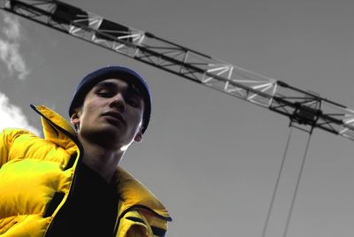 Low angle view of man looking at construction site against sky