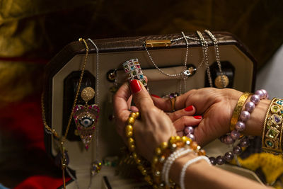 Cropped hands of woman holding jewelries