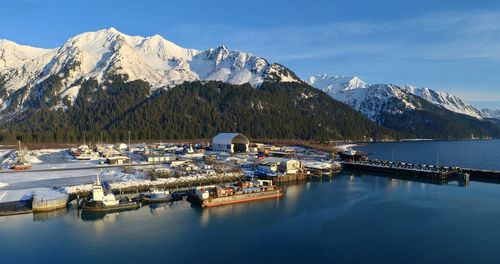 Scenic view of sea and snowcapped mountains against sky