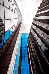 Low angle view of modern glass building against sky