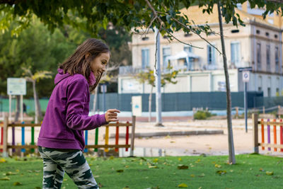 Full length of girl playing with plants