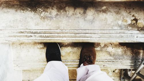 Low section of man standing on metal