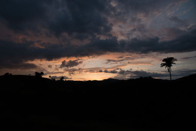 Silhouette landscape against cloudy sky