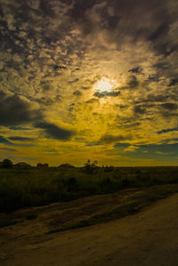 Scenic view of agricultural field against dramatic sky