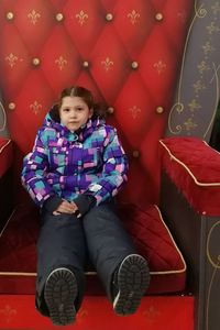 Full length of cute girl sitting in traditional clothing