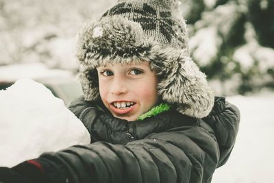 Portrait of boy holding snow