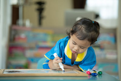 Close-up of girl drawing on slate