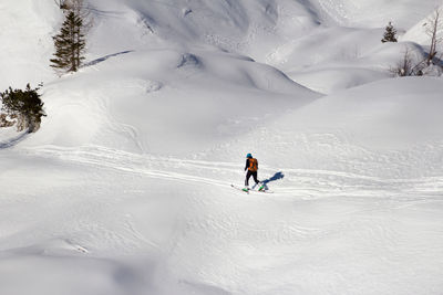 Full length of woman skiing on snow covered land