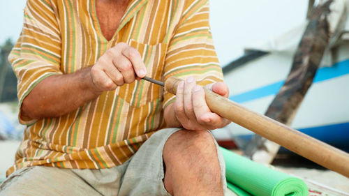 Midsection of man holding umbrella