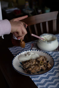 Midsection of person having breakfast on table