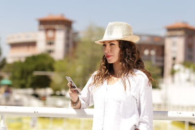 Young woman using mobile phone in city
