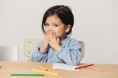 Portrait of girl with color pencil at home