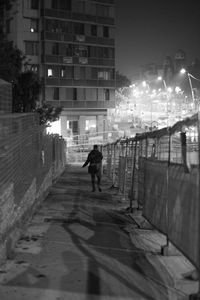 Man walking on illuminated street at night