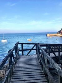 Pier over sea against blue sky