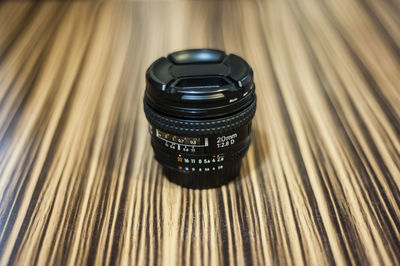 Close-up of camera lens on wooden table