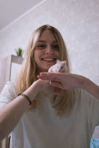 Happy girl with a small white syrian hamster. friendship between human and animal. 